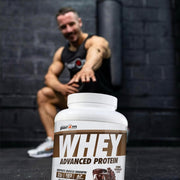 Person sitting on a black mat with a container of Perk Whey Advanced Protein in the foreground.