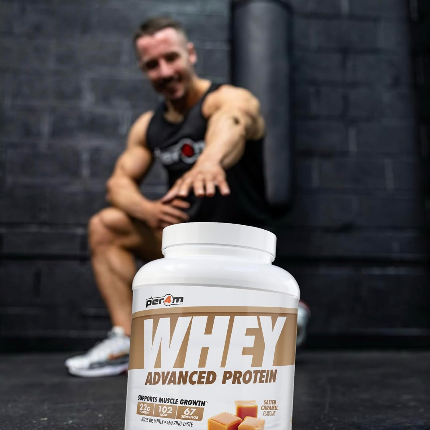 Person sitting on a bench with a container of Perk Whey Advanced Protein in the foreground.
