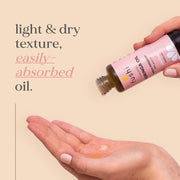 Hand holding a bottle of Fushi organic oil with text about texture and absorption on a beige background