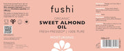 Fushi Organic Sweet Almond Oil label on a pink background