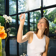 Hand spraying Puressentiel air mist in a living room.