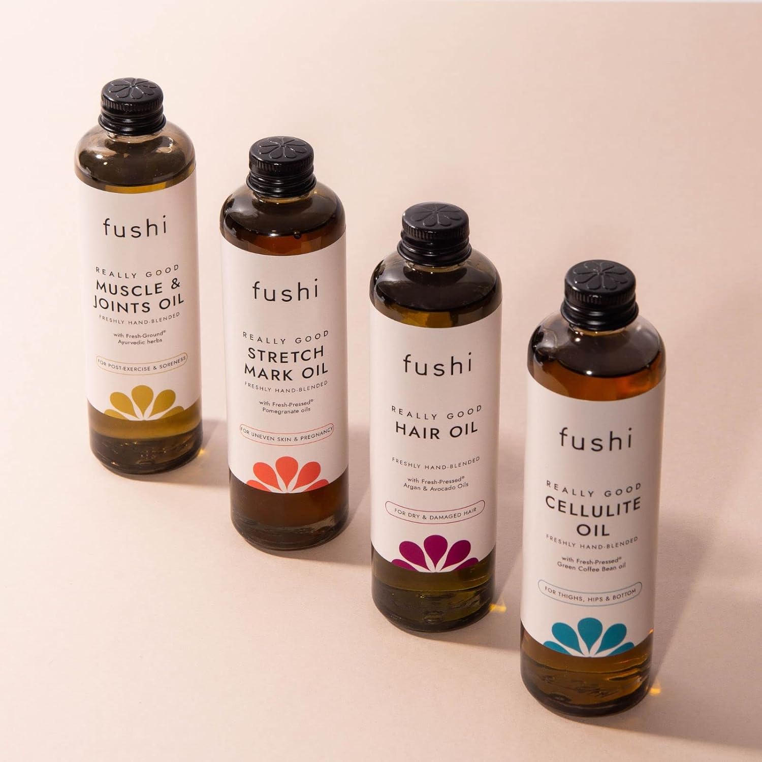 Four bottles of fushi oils on a beige background