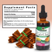 Cat's Claw supplement bottle with dried root bundles and supplement facts label on a light pink background