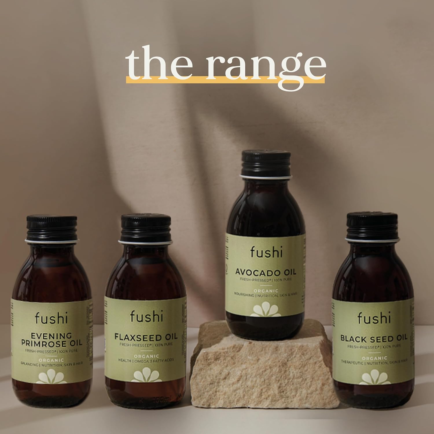 Fushi oil bottles on a stone surface with a neutral background