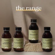 Fushi oil bottles on a stone surface with a neutral background