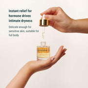 Hand holding a dropper bottle with text about hormone-driven intimate dryness relief.