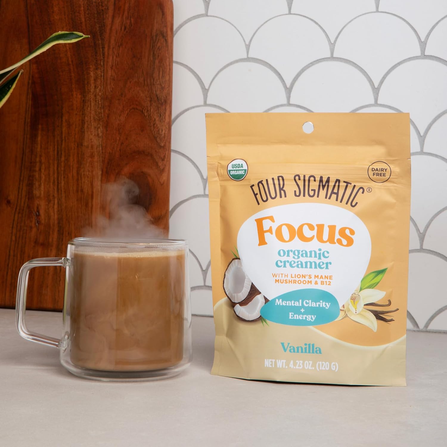 Four Sigmatic Focus Organic Creamer package next to a steaming mug of coffee.