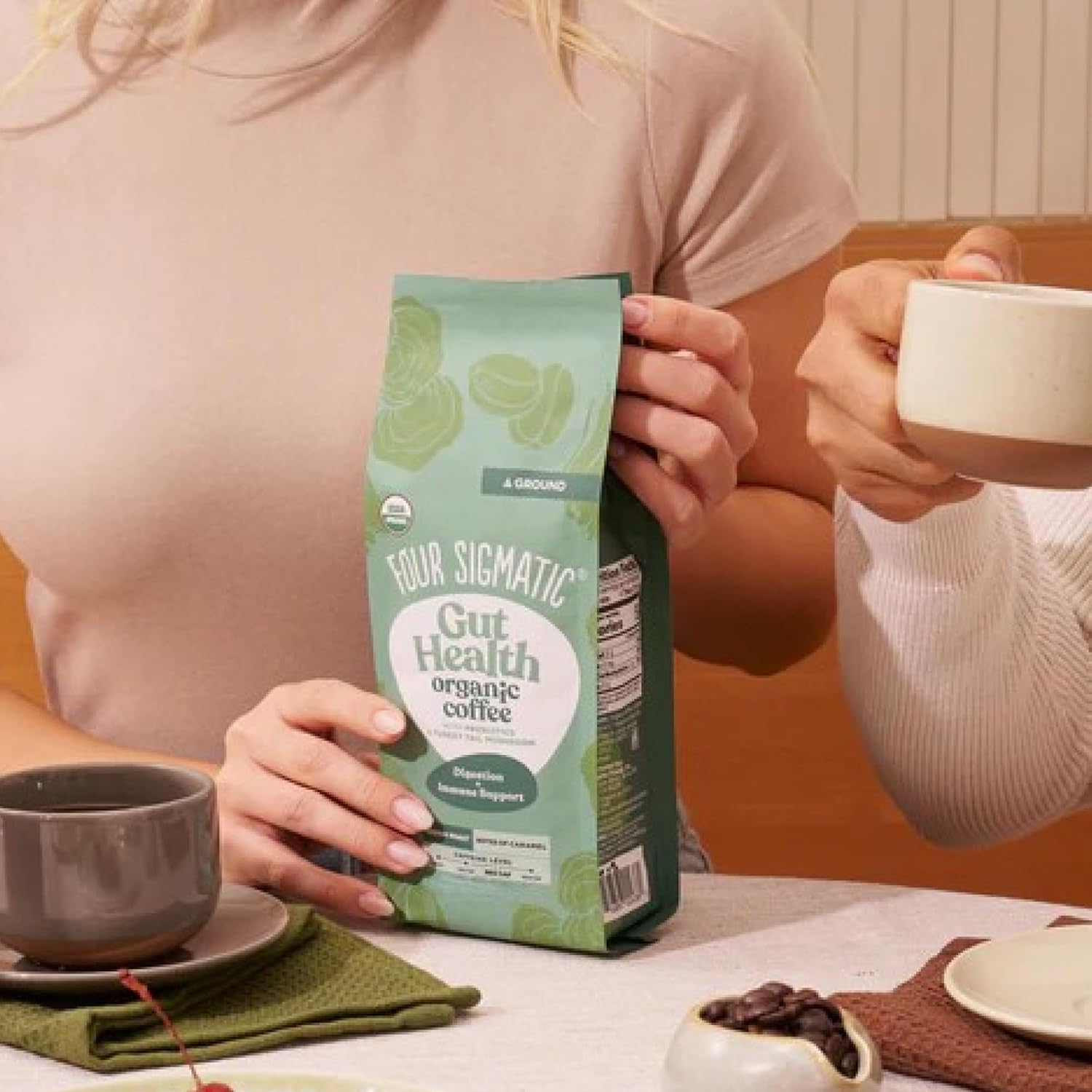 How to Use: Four Sigmatic ground coffee being scooped next to a coffee maker.