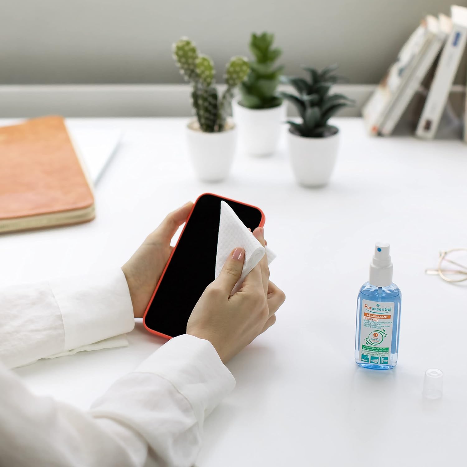 Hand spraying Puressentiel lotion for cleansing.