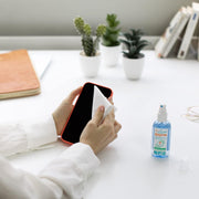 Hand spraying Puressentiel lotion for cleansing.