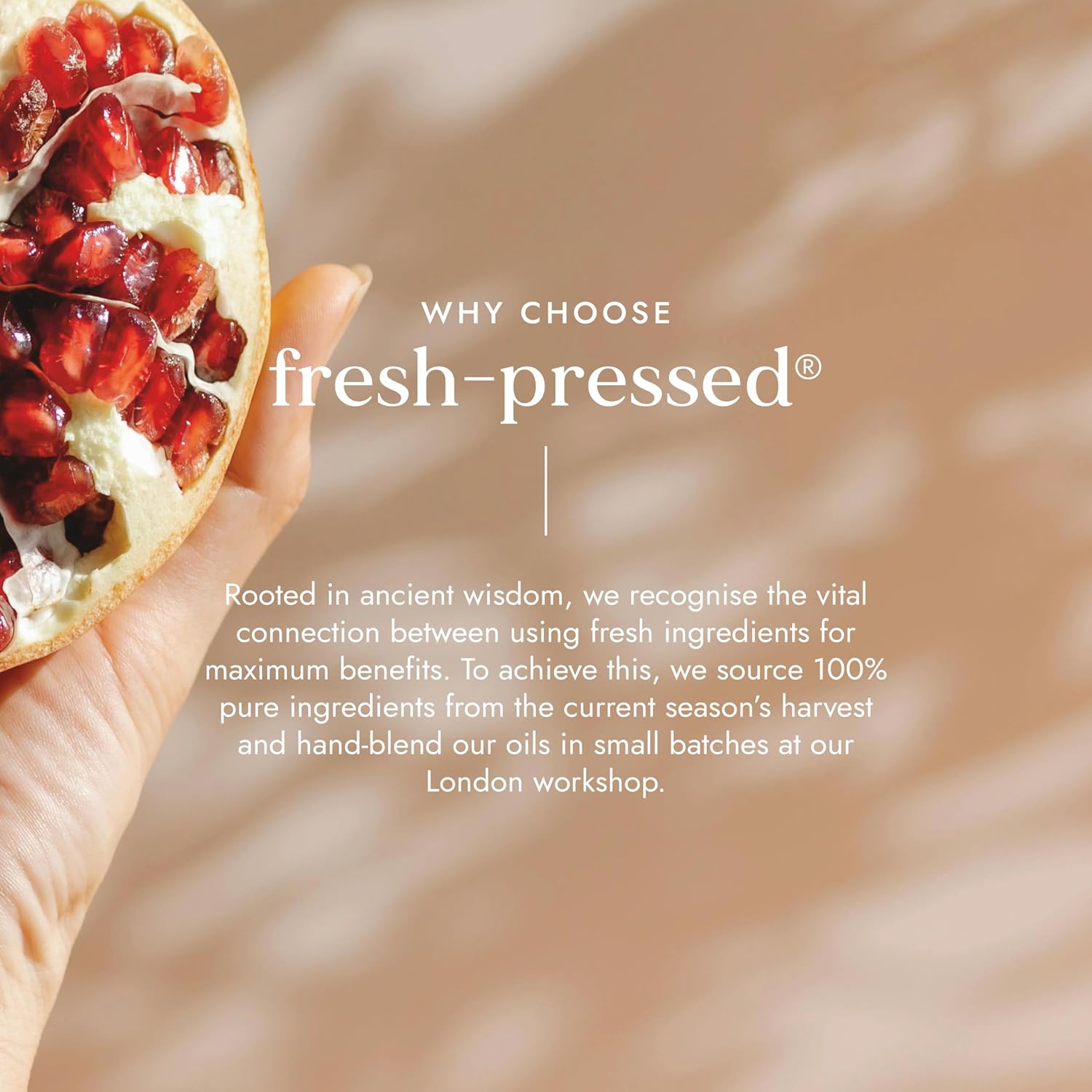 Pomegranate held in a hand with text about fresh-pressed products on a blurred background