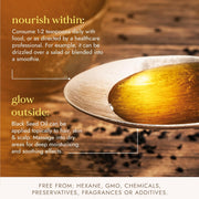 Spoon with black seed oil and text about usage on a wooden background