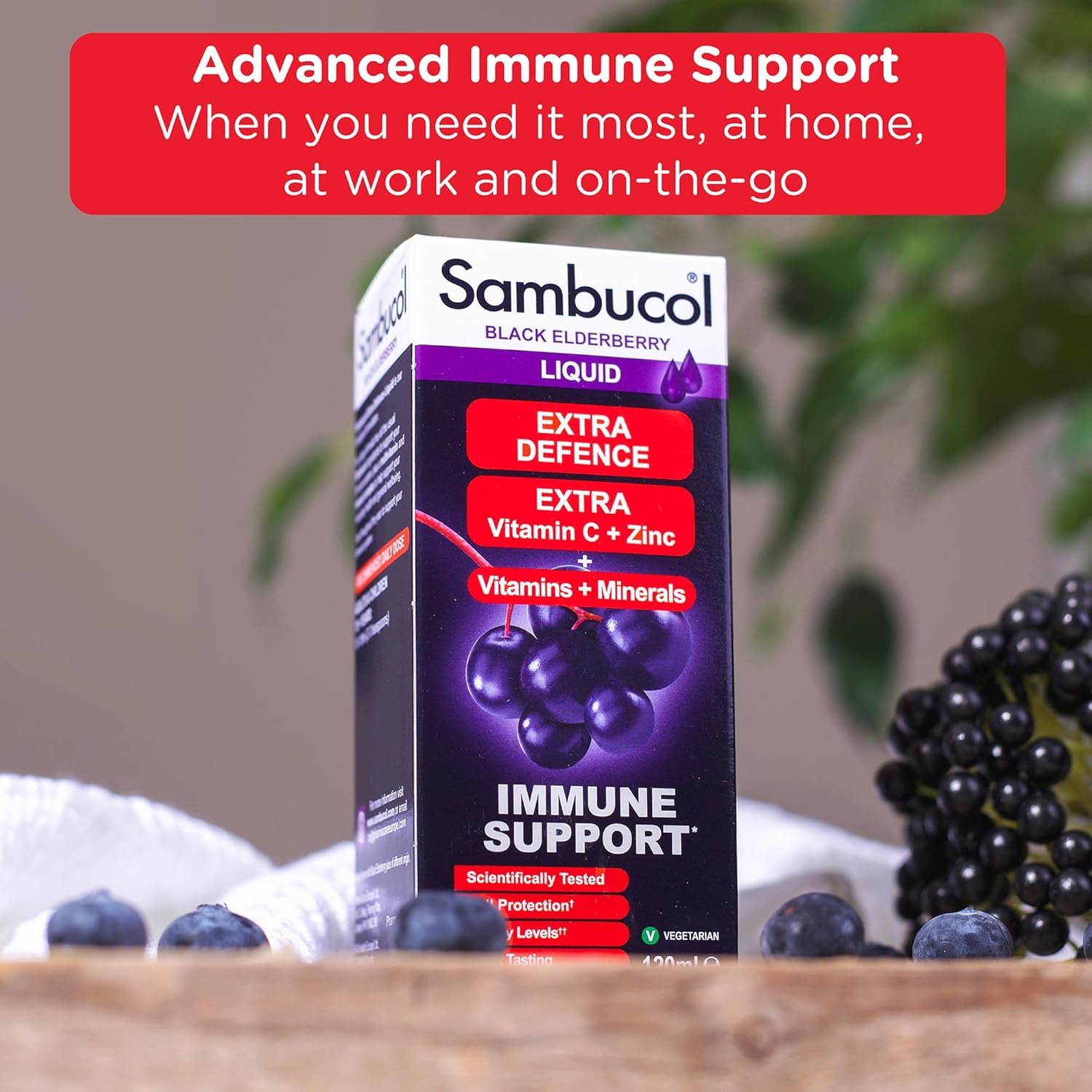 Sambucol Black Elderberry Liquid packaging with black elderberries on a wooden surface.