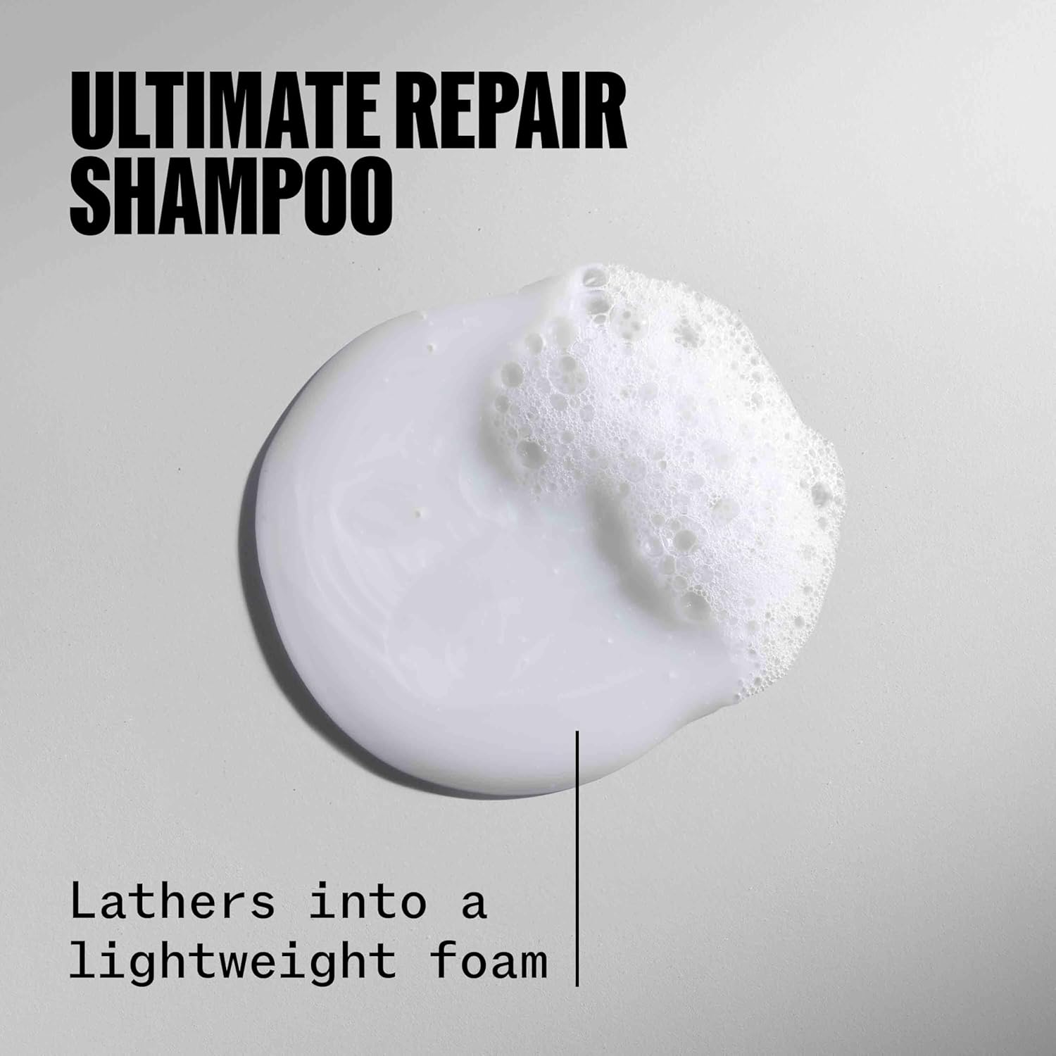Close-up of WELLA ULTIMATE REPAIR Shampoo label showing key features.