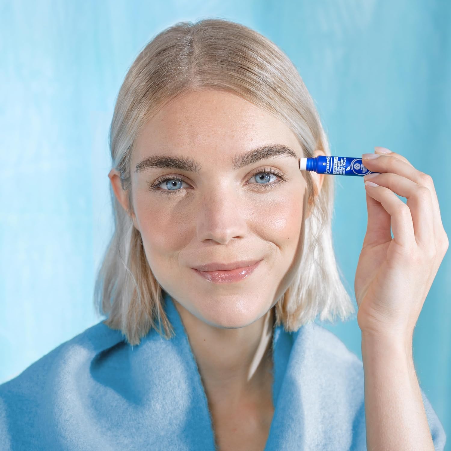 Hand applying Puressentiel roll-on to temple for soothing massage.