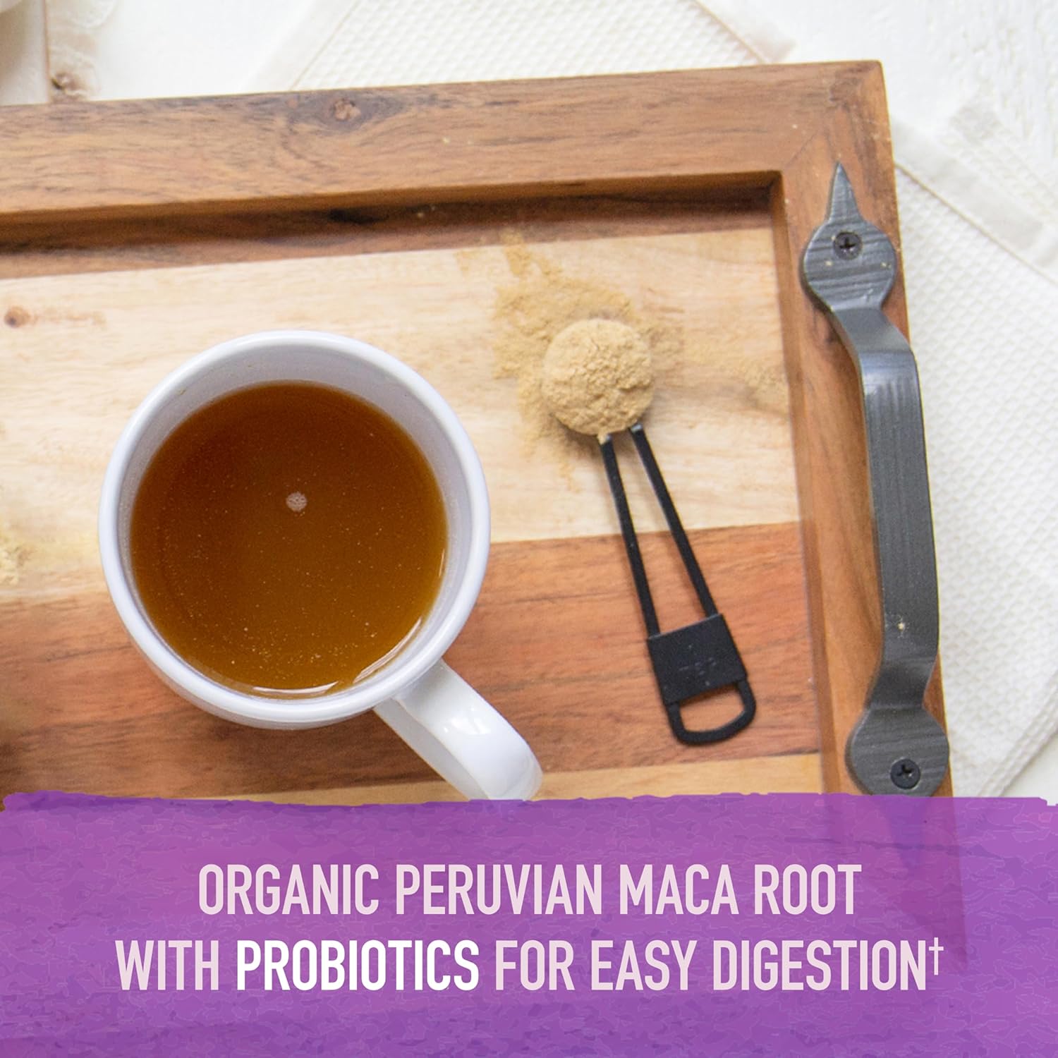 Teaspoon of maca powder being added to a cup.