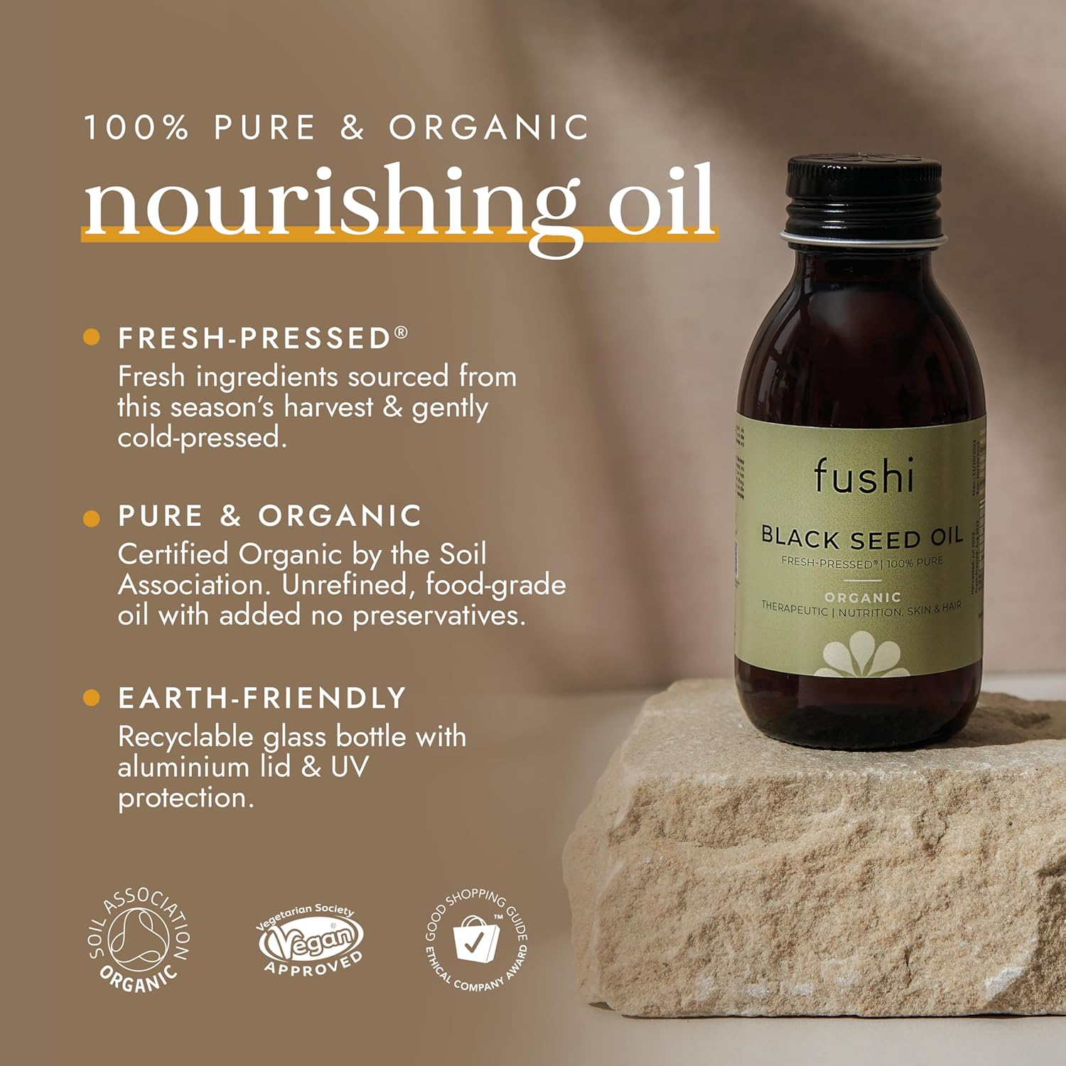 Bottle of fushi Black Seed Oil on a stone surface with product details on a brown background