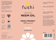 Fushi Organic Neem Oil packaging with branding and product details on a pink background