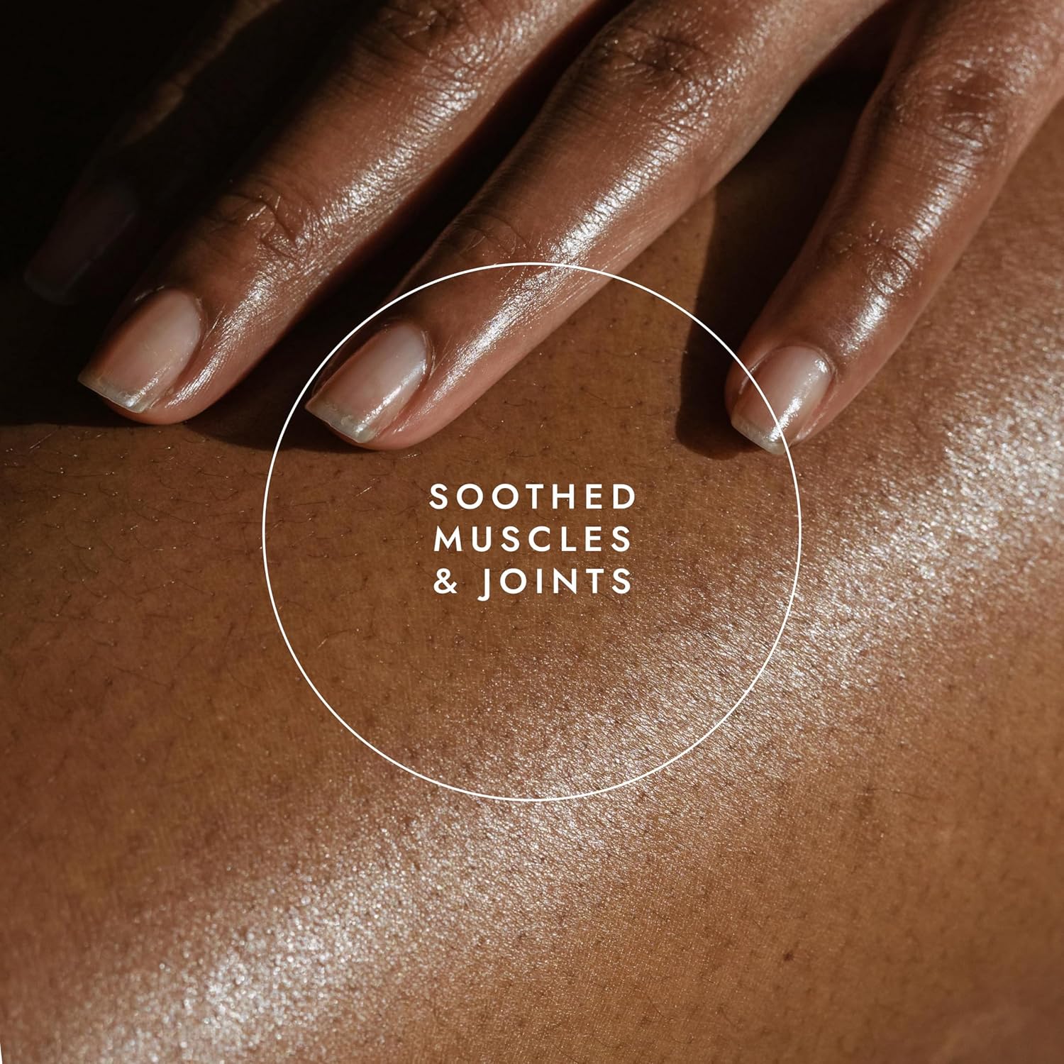 Close-up of a hand touching skin with text 'Soothed Muscles & Joints' on a brown background
