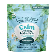 Four Sigmatic Calm organic herbal tea package with green leaves and floral elements on a light blue background.