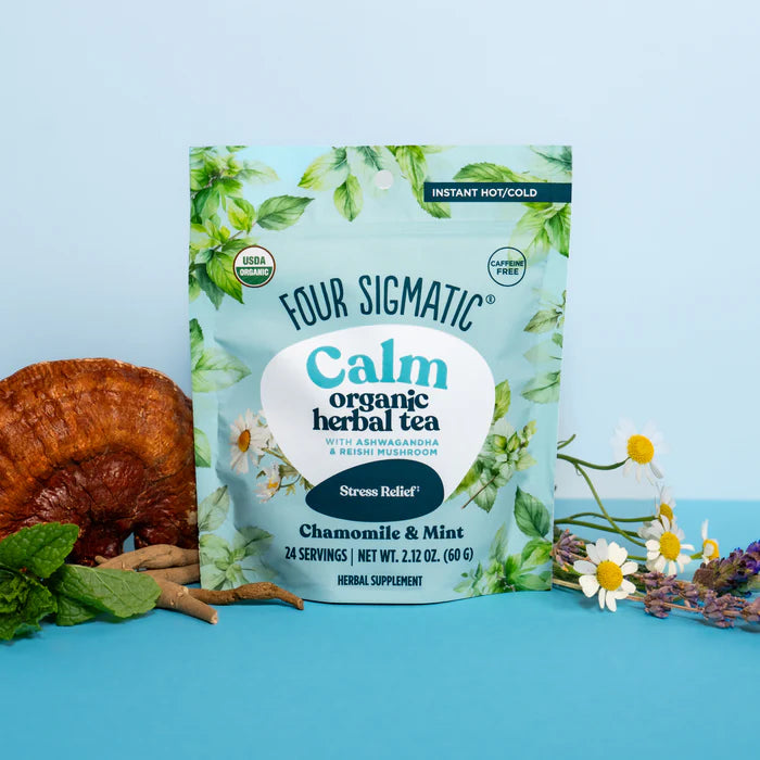 Four Sigmatic Calm organic herbal tea package on a blue background with natural elements.