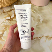 Hand holding a tube of Hope's Relief conditioner on a marble surface