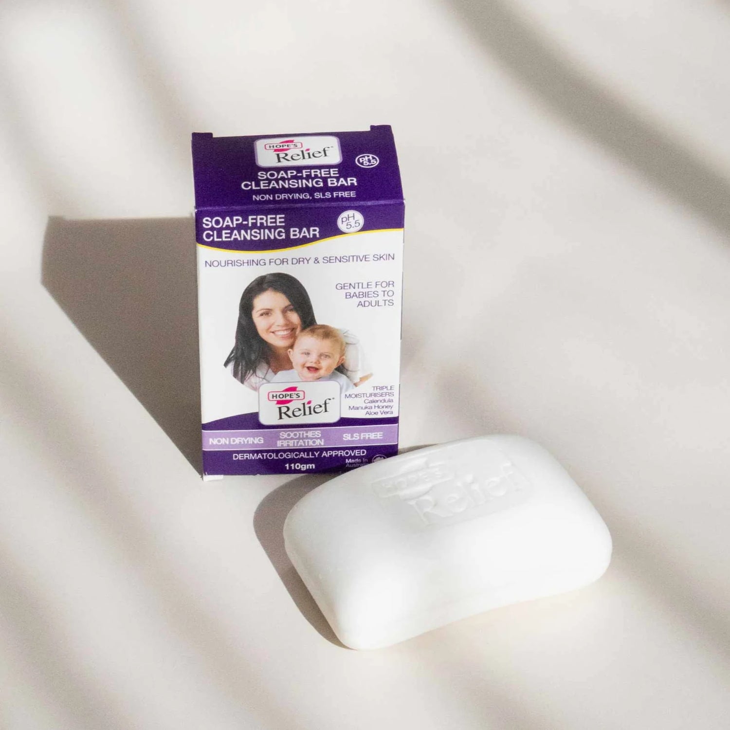 Soap-free cleansing bar with packaging on a light background