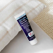 Tube of gel-lotion for dry and itchy skin on a textured surface