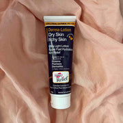 Tube of Derma-Lotion for dry skin and itchy skin on a pink fabric background