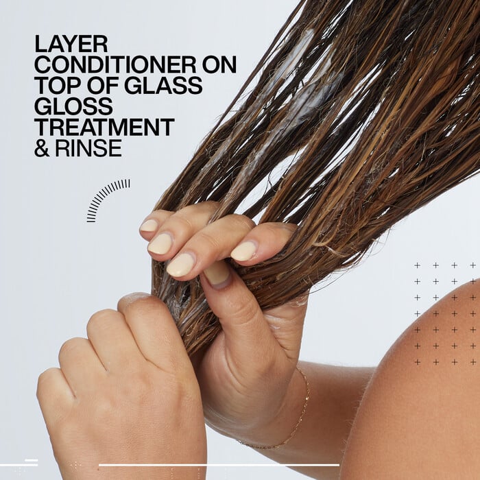 Redken Conditioner being applied to the lengths of wet hair.