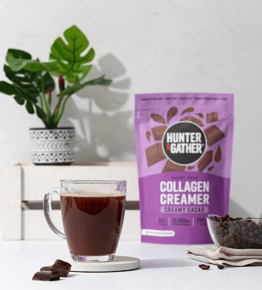 Hunter & Gather Collagen Creamer package with a cup of coffee and chocolate chips on a white surface.