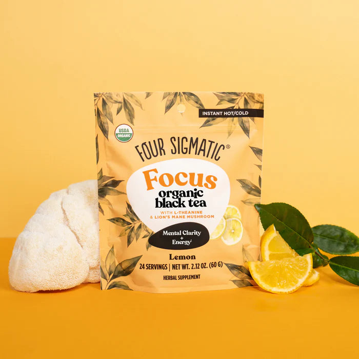 Four Sigmatic Focus organic black tea package on a yellow background with lemon slices and leaves.