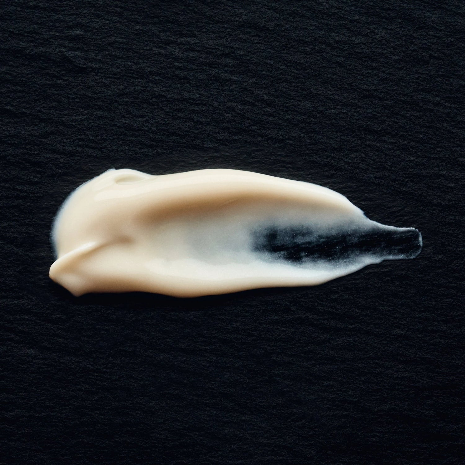 White cream smear on a black background
