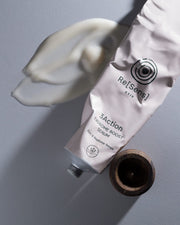 Tube of Re[Sens] 3Actionosome Boost Serum with a wooden applicator on a gray background