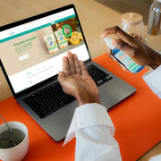 Hand spraying Puressentiel lotion for cleansing.