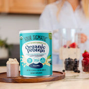 Four Sigmatic Organic Protein canister on a wooden board with a blurred kitchen background