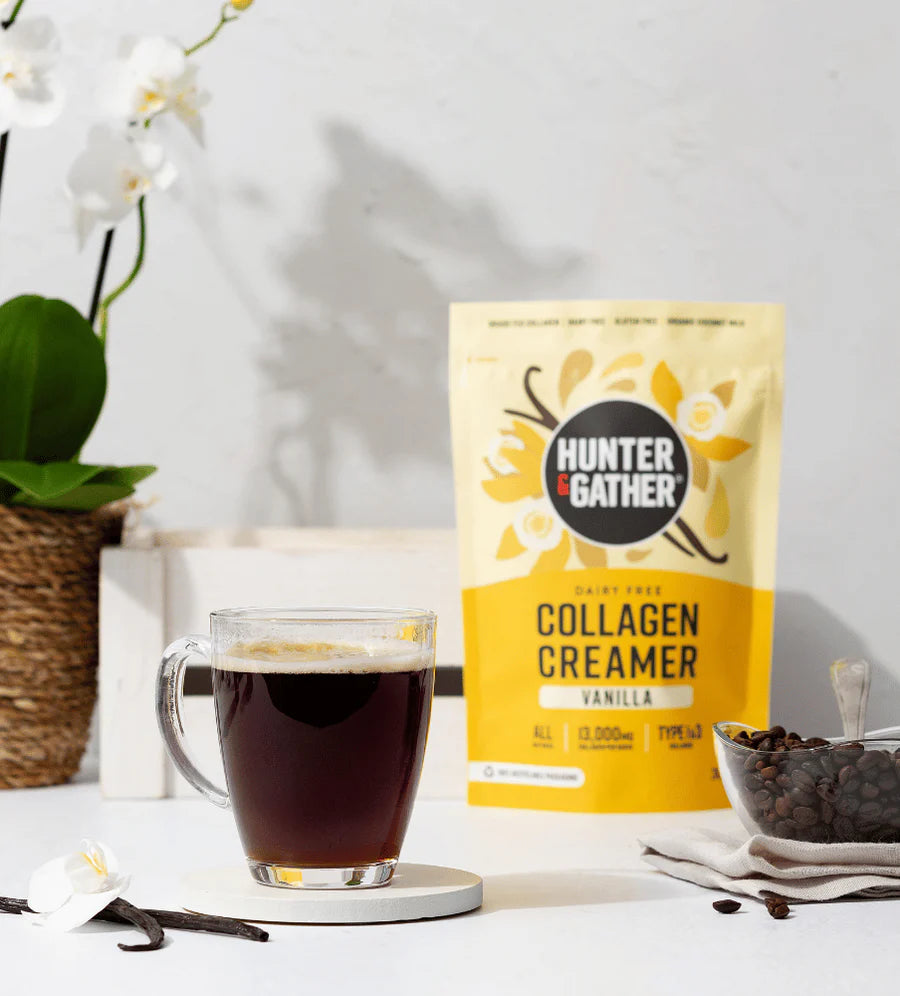 Hunter & Gather collagen creamer package with a glass of coffee on a white surface.